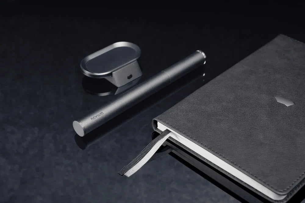Black novium notebook, Carrying Case and productivity card holder desk accessory on a dark desk